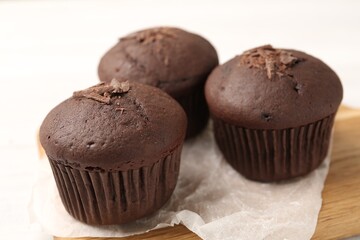 Delicious cupcakes with chocolate crumbles on wooden board, closeup
