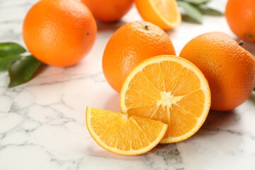 Delicious ripe oranges on white marble table, closeup