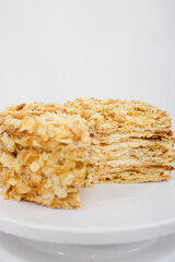 Napoleon cake in a cut on a white tray isolated on a white background. Cake of puff pastry with sour cream. Copy space. 