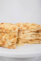 Napoleon cake in a cut on a white tray isolated on a white background. Cake of puff pastry with sour cream. Copy space. 
