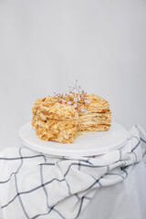Napoleon cake in a cut on a white tray isolated on a white background. Cake of puff pastry with...