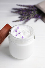 Fototapeta na wymiar Jar of face cream and beautiful lavender on white wooden table