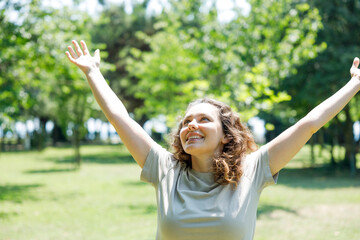 Woman breathing fresh air outdoors in summer, celebrating while out in nature