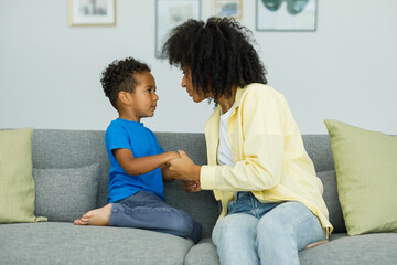Angry young mother arguing with little son who is misbehaving by being stubborn while talking to him. The concept of the conflict of parents and children