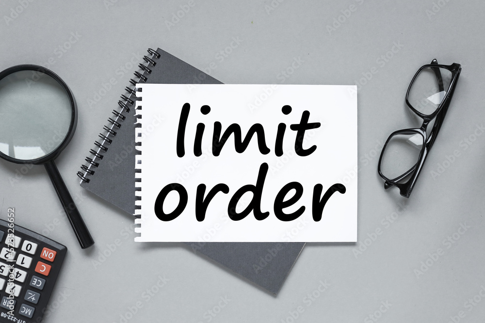 Poster limit order tex on a notepad near a magnifying glass and a calculator. grey background. business con