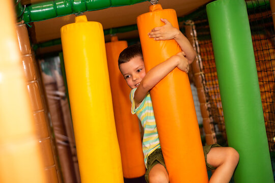 A cute cheerful child on a colorful obstacle course in a children's play center.