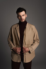 Obraz premium Stylish man in autumn outfit posing isolated on grey.