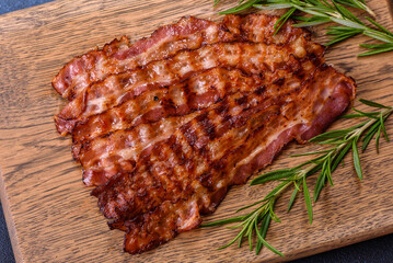 Delicious roasted ham with slices on a wooden cutting board with spices and herbs