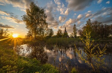 Beautiful summer landscape with a church at sunset