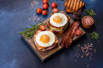 Fresh, delicious sandwiches with fried egg, ham, butter, avocado and sesame seeds