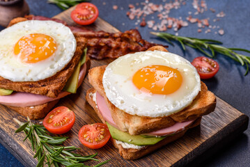 Fresh, delicious sandwiches with fried egg, ham, butter, avocado and sesame seeds