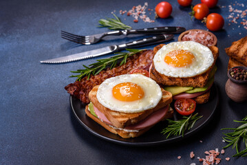 Fresh, delicious sandwiches with fried egg, ham, butter, avocado and sesame seeds