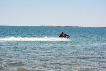 Fototapeta na wymiar Water bike. Jet ski rides on the wave of the sea