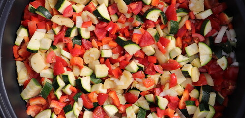 a vegetable pan with courgettes, onions, tomatoes, potatoes and peppers