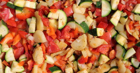 a vegetable pan with courgettes, onions, tomatoes, potatoes and peppers