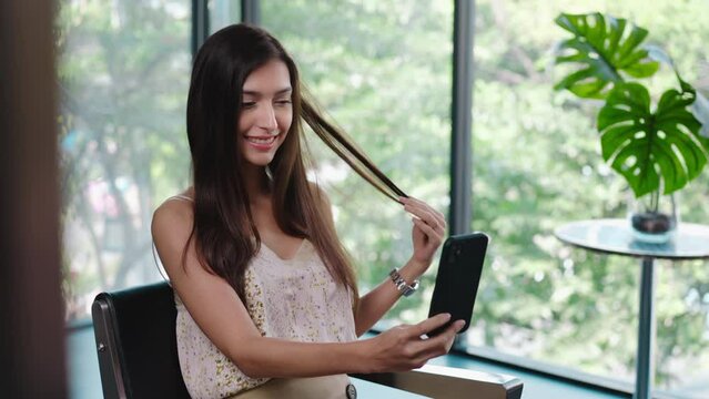 Caucasian beautiful woman customer take a photo after change hair style. Attractive young female using smartphone selfie after getting treatment service from hairdresser, feeling happy at beauty salon