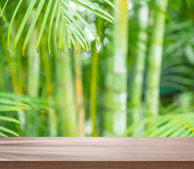 Empty board or table top and blurred green bamboo culms. Place for your product display.