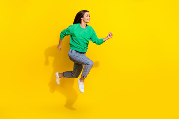 Fototapeta na wymiar Full length photo of active young lady run fast hurry shopping mall sales wear stylish green sportswear isolated on yellow color background