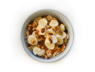 A bowl with the oatmeal, bananas and nuts with the selective focus. 