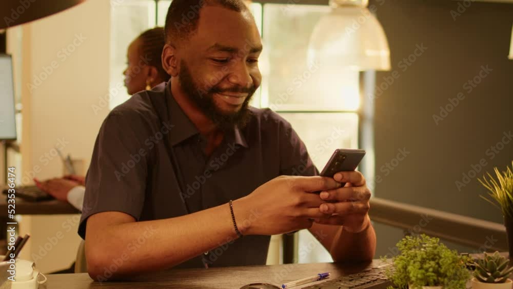 Poster portrait of employee working on smartphone app at startup job during sunset, using online research d