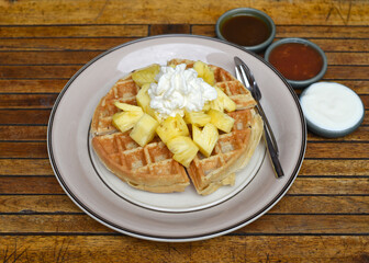 Belgium waffles with pineapple fruit and ice cream on a plate