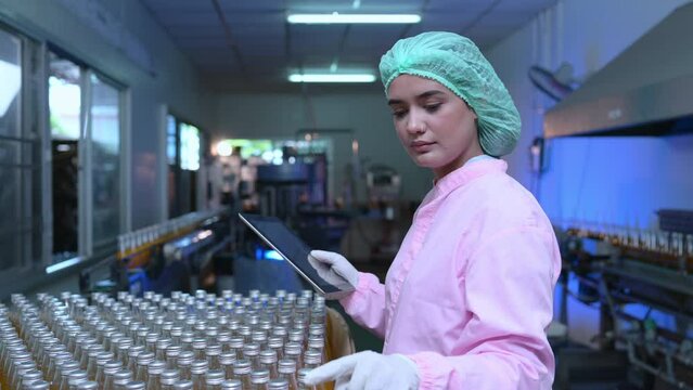 Product quality control staff at the fruit juice production line Perform product quality checks To ensure that the products produced are of good quality before being delivered to consumers further