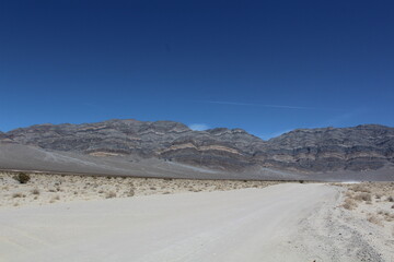 Road leading to mountains with colorful and unique rock formations in Death Valley National Park