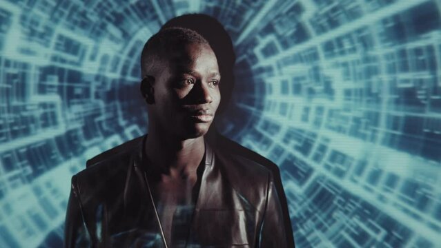 Conceptual medium close-up of young adult African American man wearing stylish leather jacket turning face to camera, futuristic image projected on wall