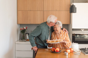 Happy senior couple with homemade sweet braided bread with raisins.