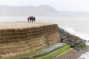 A family walking along the Cb at Lyme Regis