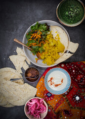 Vegetarian indian rice and cauliflower pilaf, papad and salad along with pickles and yougurt
