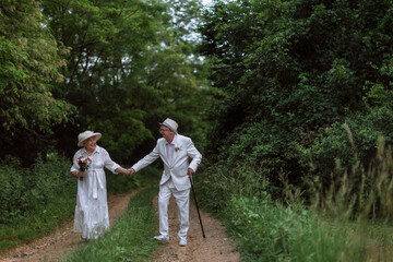 Naklejka na ściany i meble Senior couple having wedding photography in forest during summer day.