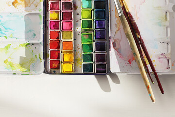 Watercolor palette and paintbrush. Top view. Creative mess in the artistic workshop.