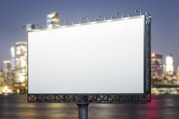 Blank white billboard on city buildings background at night, perspective view. Mockup, advertising concept