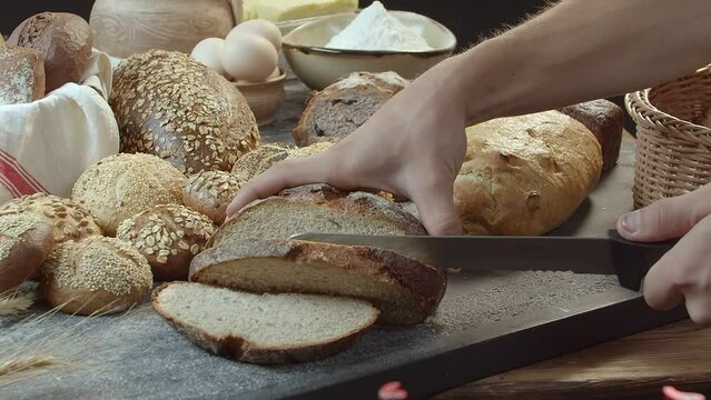 Hands cutting the baked Dutch bread on the table