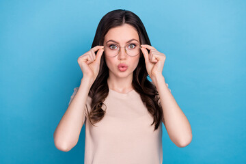 Obraz premium Photo of funky funny young girl with bad eyesight vision try on spectacles isolated on blue color background