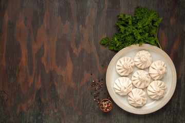 National Georgian cuisine. Raw Khinkali with meat. Khinkali on a ceramic plate. Top view. Copy space