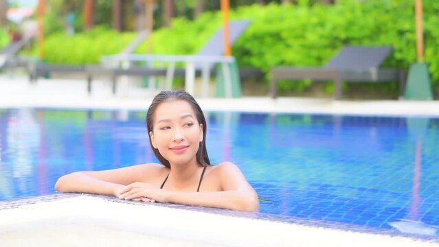 Sexy Exotic Female Model in Swimming Pool of Tropical Resort, Looking at Camera With Smile
