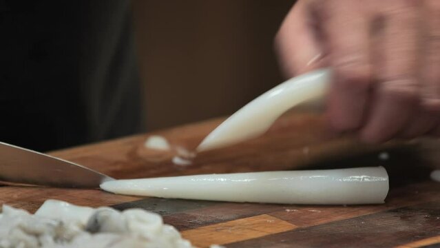 hands of a person cutting squid 