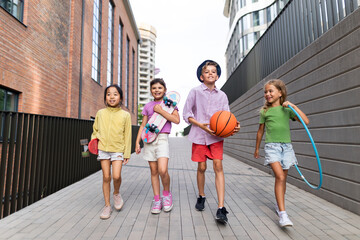 Obraz premium Happy kids playing and talking together in city, during summer day. Looking at camera, low angle view.