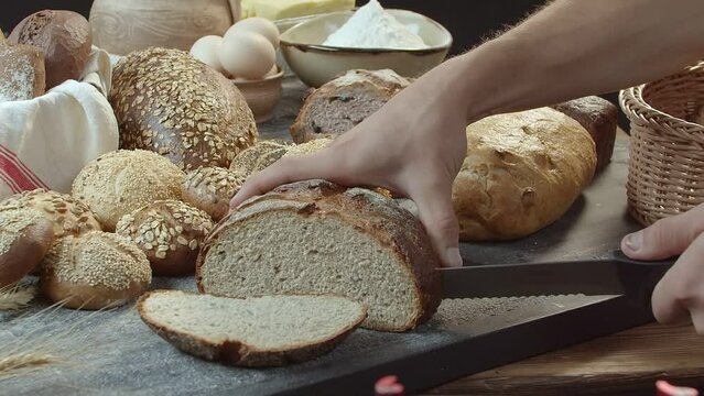 Hands cutting the baked Dutch bread on the table