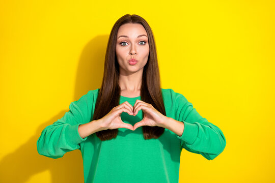 Photo of young beautiful pretty nice girl showing love heart pouted lips isolated on yellow color background