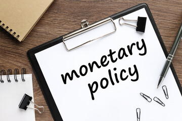 Monetary policy text on black folder on wooden table