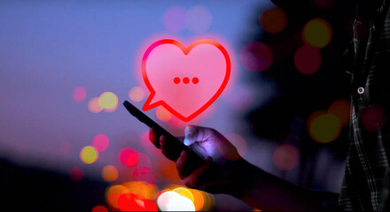 illustrierte rote Sprechblase in Form eines Herzens über einer Hand, die ein Smartphone mit...