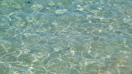 Reflections on clear sea water on a windy day.