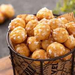 Delicious French Chouquette Choux Pastry dessert Pearl Sugar Puff on gray table background.