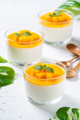 Delicious double colored mango panna cotta mousse pudding on white table background.