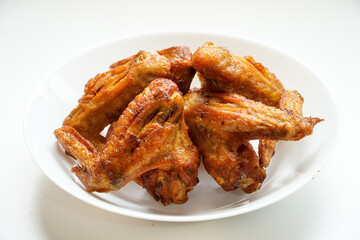 spicy fried chicken wings on white plate on top view floor with copy space