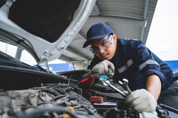 Asian auto mechanic working on car engines Repair and service customer service Work on the engine in the garage. automobile car concept. - Powered by Adobe