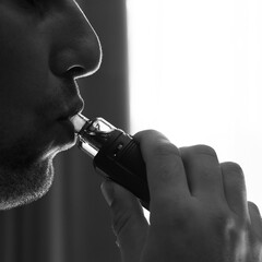 Man smoking electronic cigarette, smoke and lips close-up.